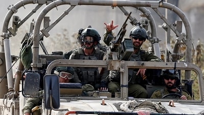 Israel-Hamas War: An Israeli soldier gestures while riding in a military vehicle, amid the ongoing conflict between Israel and Hamas. (Reuters)