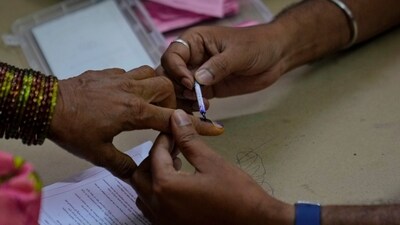 A polling officer marks the finger of a woman with indelible ink during the Telangana state assembly elections. (AP) A polling officer marks the finger of a woman with indelible ink during the Telangana state assembly elections. (AP)