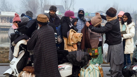 People buy warm clothes from the roadside after the city experienced the coldest night of the season in Srinagar.(ANI)