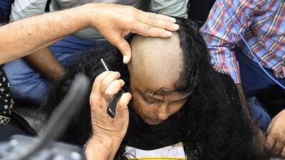 A woman candidate shaves her head to protest against the multi-crore school jobs scam in Kolkata on Saturday. (Photo by Samir Jana/ Hindustan Times) A woman candidate shaves her head to protest against the multi-crore school jobs scam in Kolkata on Saturday. (Photo by Samir Jana/ Hindustan Times)