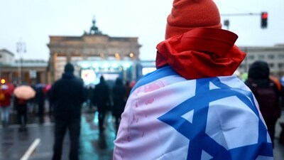 A person carries an Israeli flag during a protest against antisemitism at the Brandenburg Gate, amid the ongoing conflict between Israel and Palestinian Islamist group Hamas, in Berlin, Germany, December 10, 2023. (REUTERS)