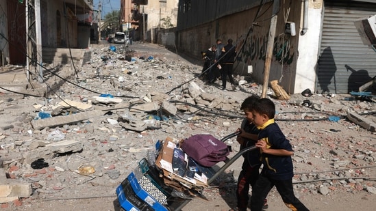 TOPSHOT - Young boys push a loaded tolley in Rafah in the southern Gaza Strip on December 10, 2023, as battles between Israel and the Palestinian Hamas movement. Israeli forces pushed into southern Gaza on December 10, where hundreds of thousands of civilians have fled in search of shelter from bombardments and intense fighting with Hamas militants. (Photo by MOHAMMED ABED / AFP) TOPSHOT - Young boys push a loaded tolley in Rafah in the southern Gaza Strip on December 10, 2023, as battles between Israel and the Palestinian Hamas movement. Israeli forces pushed into southern Gaza on December 10, where hundreds of thousands of civilians have fled in search of shelter from bombardments and intense fighting with Hamas militants. (Photo by MOHAMMED ABED / AFP)