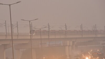 Commuters out on a smoggy morning amid rising air pollution level at Anand Vihar, in New Delhi. (HT)