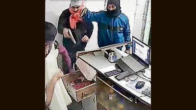 A CCTV grab showing the robbers pointing guns at the shop owner in Ludhiana. (HT Photo) A CCTV grab showing the robbers pointing guns at the shop owner in Ludhiana. (HT Photo)
