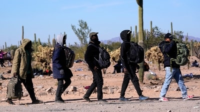 A group of migrants walk to a van as hundreds of migrants gather along the border Tuesday, Dec. 5, 2023, in Lukeville, Ariz. (AP Photo/Ross D. Franklin) (AP) A group of migrants walk to a van as hundreds of migrants gather along the border Tuesday, Dec. 5, 2023, in Lukeville, Ariz. (AP Photo/Ross D. Franklin) (AP)