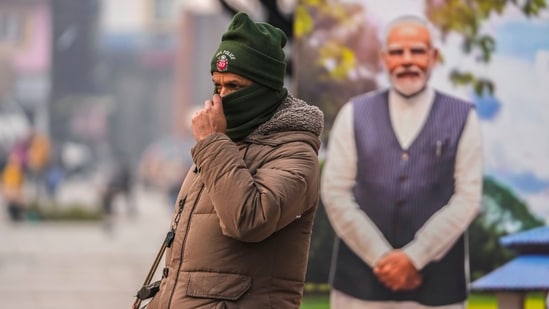 A policeman stands guard near a cutout portrait of Prime Minister Narendra Modi displayed at the main market in Srinagar on December 11. (AP)
