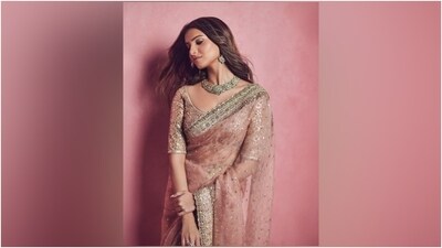Tara's saree comes in a pleasant mauve pink shade and features sequinned embellishments, gold taar embroidery in a floral pattern, a scalloped hem, and a broad gold border featuring intricate designs. She draped the six yards elegantly, letting the heavily embellished pallu fall from the shoulder in a floor-sweeping length. (Instagram) Tara's saree comes in a pleasant mauve pink shade and features sequinned embellishments, gold taar embroidery in a floral pattern, a scalloped hem, and a broad gold border featuring intricate designs. She draped the six yards elegantly, letting the heavily embellished pallu fall from the shoulder in a floor-sweeping length. (Instagram)