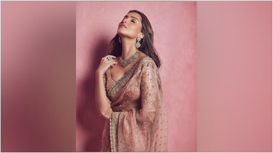 Tara styled the saree with a matching mauve-coloured blouse featuring a boat-plunging neckline, mirror embellishments, floral embroidery, gota patti work, quarter-length sleeves, fitted bust, and a cropped hem. An ornated gold choker necklace, matching jhumkis, a statement ring, and high heels gave a finishing touch. (Instagram)