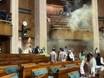Footage captured from inside the chamber showed a chaotic scene as one man desperately hurdled desks, creating a frenzied atmosphere. His accomplice meanwhile unleashed a thick veil of smoke from the visitors' gallery, enveloping the Lok Sabha in a yellowish mist. Footage captured from inside the chamber showed a chaotic scene as one man desperately hurdled desks, creating a frenzied atmosphere. His accomplice meanwhile unleashed a thick veil of smoke from the visitors' gallery, enveloping the Lok Sabha in a yellowish mist.