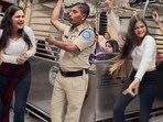 Home guard dancing with a passenger aboard Mumbai local. 