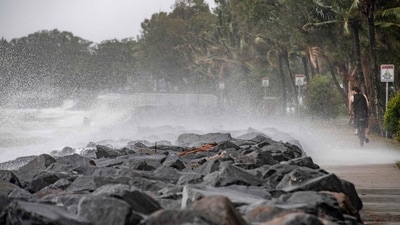 A cyclist pedals along boardwalk as Cyclone Jasper approaches landfall in Cairns in far north Queensland. (AFP)