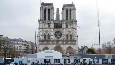 People stand in front of Notre-Dame de Paris Cathedral during the reconstruction work on the Ile de la Cite in Paris. (AFP)