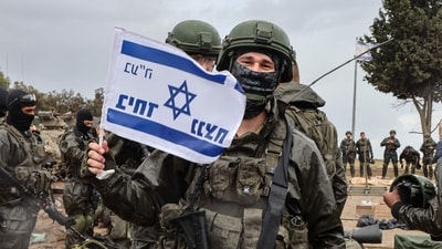 Israel-Hamas War: An Israeli soldier poses with a flag of Israel as he prepares to return to the Gaza Strip, near the border area in southern Israel. (AFP) Israel-Hamas War: An Israeli soldier poses with a flag of Israel as he prepares to return to the Gaza Strip, near the border area in southern Israel. (AFP)