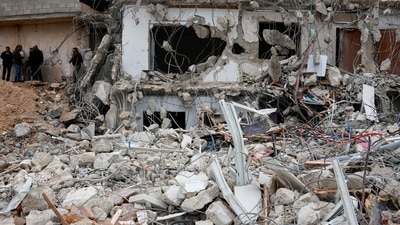 Israel-Hamas War: Palestinians stand near the rubble of a demolished house, amid the ongoing conflict between Israel and Hamas. (Reuters)