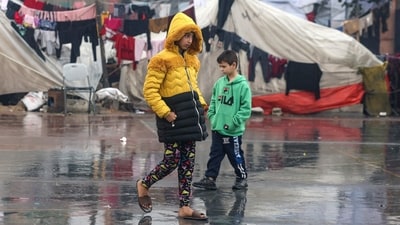 Israel-Hamas War: Palestinians children walk near makeshift tents at a camp set up on a schoolyard in Rafah. (AFP) Israel-Hamas War: Palestinians children walk near makeshift tents at a camp set up on a schoolyard in Rafah. (AFP)