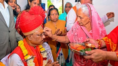 Jasmani Devi, mother of Chhattisgarh Chief Minister-designate Vishnu Deo Sai, applies 'tilak' on his forehead before his swearing-in ceremony, in Raipur. (PTI) Jasmani Devi, mother of Chhattisgarh Chief Minister-designate Vishnu Deo Sai, applies 'tilak' on his forehead before his swearing-in ceremony, in Raipur. (PTI)