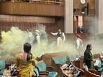 An India TV video grab shows the scenes inside the Lok Sabha after an unidentified man jumped from the visitors’ gallery, evaded MPs, and released coloured smoke. (ANI) An India TV video grab shows the scenes inside the Lok Sabha after an unidentified man jumped from the visitors’ gallery, evaded MPs, and released coloured smoke. (ANI)