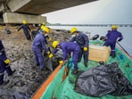 Chennai: Rescue officials clean after an oil spill in the Bay of Bengal off the Ennore Creek area in the aftermath of Cyclone Michaung, in Chennai, Friday. Chennai: Rescue officials clean after an oil spill in the Bay of Bengal off the Ennore Creek area in the aftermath of Cyclone Michaung, in Chennai, Friday.