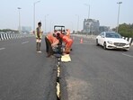 Workers of NHAI repair the crack on Iffco Chowk parallel flyover in Gurugram on Monday. (Parveen Kumar/HT Photo) Workers of NHAI repair the crack on Iffco Chowk parallel flyover in Gurugram on Monday. (Parveen Kumar/HT Photo)