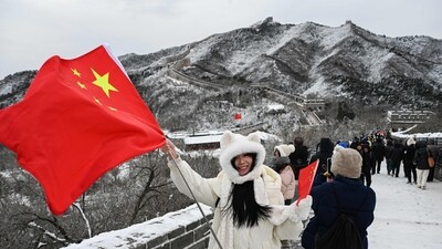 At Badaling, north of Beijing, a woman proudly holds the Chinese national flag on the snow-clad Great Wall after overnight snowfall. (AFP) At Badaling, north of Beijing, a woman proudly holds the Chinese national flag on the snow-clad Great Wall after overnight snowfall. (AFP)