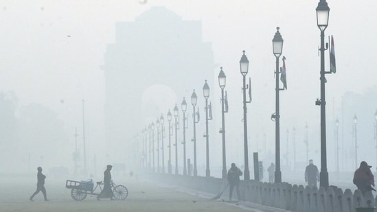 Workers at the lawn along the Kartavya Path during a cold and foggy winter morning, in New Delhi, Friday, Dec. 15, 2023. (PTI Photo/Arun Sharma)