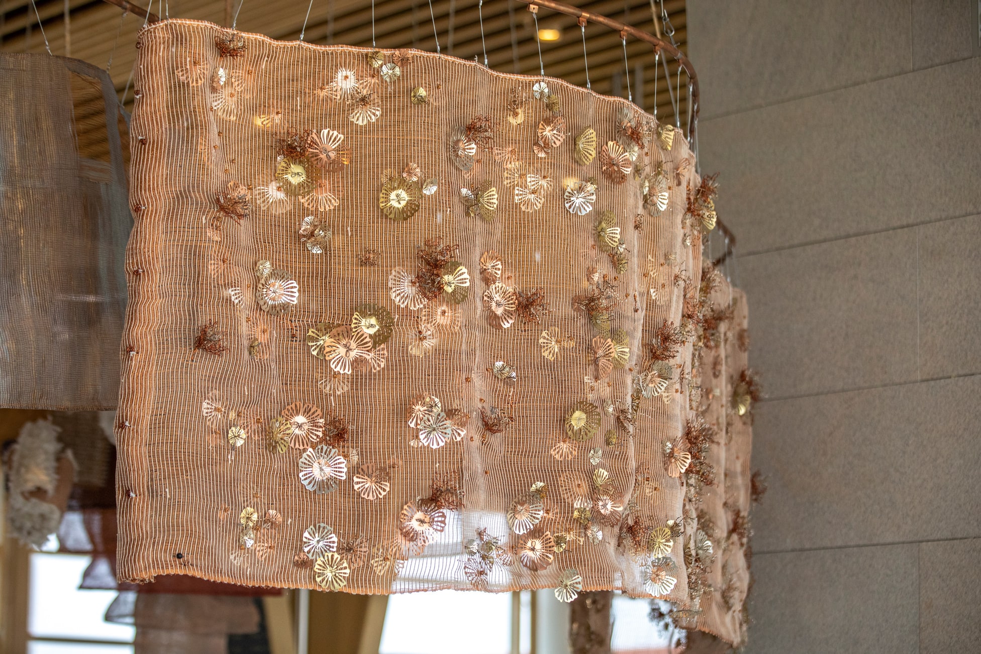 A wall of copper wire and cotton yarn with handcrafted copper flowers is happiness. A wall of copper wire and cotton yarn with handcrafted copper flowers is happiness.