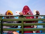 Women display their voter's identity card sitting in the back of a truck in Chachiyawas, near Ajmer, India, Saturday, Nov. 25, 2023. 