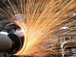 A worker wearing a face mask works on a production line manufacturing bicycle steel rim at a factory in Hangzhou, Zhejiang province, China.