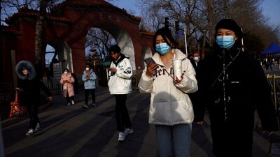 People, wearing masks to prevent coronavirus disease (COVID-19), walk along the street in Beijing, China, on February 14. (Reuters)