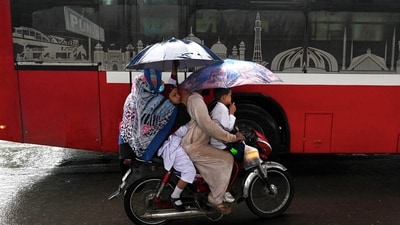 Pakistan Artificial Rain: A family rides a bike amid rain in Lahore. (AFP) Pakistan Artificial Rain: A family rides a bike amid rain in Lahore. (AFP)