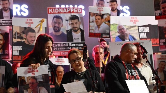 Israel-Hamas War: Relatives of Israeli hostages held in Gaza since the October 7 attack lift portraits as they deliver a statement to the media in Tel Aviv. (AFP)