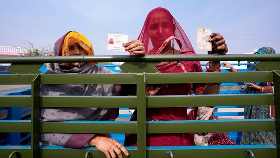Women display their voter's identity card sitting in the back of a truck in Chachiyawas, near Ajmer, India, Saturday, Nov. 25, 2023. (AP)