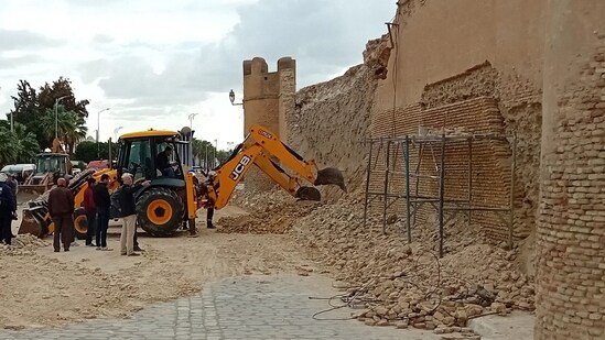 People and Civil Protection members gather at the site of a collapsed section of the ancient wall surrounding historic Kairouan in central Tunisia. (AFP)