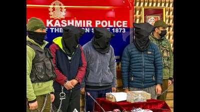 Jammu and Kashmir Police personnel with the three arrested 'hybrid' terrorists involved in the attack on a policeman in the Bemina area of Srinagar city on Sunday. (ANI) Jammu and Kashmir Police personnel with the three arrested 'hybrid' terrorists involved in the attack on a policeman in the Bemina area of Srinagar city on Sunday. (ANI)