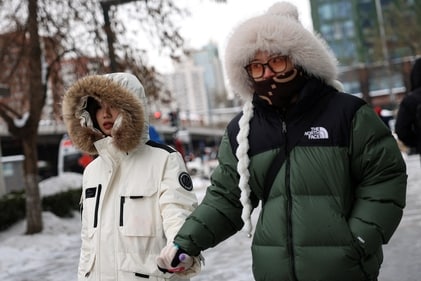 People walk on a street following snowfall in Beijing, China. (Reuters)