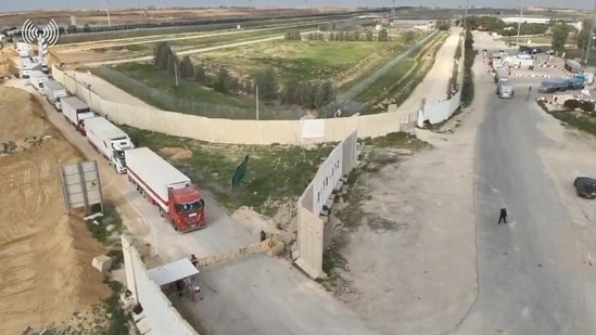 Humanitarian aid trucks wait in line to be inspected at the Kerem Shalom crossing