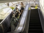 Singapore Covid Cases: Shoppers ride an escalator on Orchard Road in Singapore. Singapore Covid Cases: Shoppers ride an escalator on Orchard Road in Singapore.