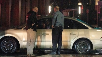 Secret Service Police, left, and security personnel question the driver of a vehicle that plowed into a parked SUV that was part of President Biden's motorcade on Sunday night in Delaware. (AP) Secret Service Police, left, and security personnel question the driver of a vehicle that plowed into a parked SUV that was part of President Biden's motorcade on Sunday night in Delaware. (AP)