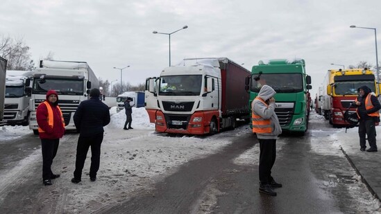 Ukrainian truck drivers are seen next to Ukrainian trucks on the parking lot near Korczowa Polish-Ukrainian border crossing (AFP)