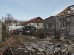 Local residents remove debris from the backyard of their house, which was damaged during a Russian drone strike, amid Russia's attack on Ukraine
