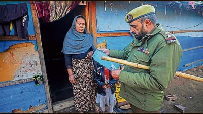 A cop checks documents of Rohingya refugees during search at a camp in Jammu on Tuesday (PTI) A cop checks documents of Rohingya refugees during search at a camp in Jammu on Tuesday (PTI)
