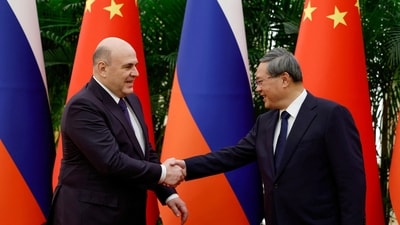 Russian Prime Minister Mikhail Mishustin shakes hands with Chinese Premier Li Qiang (Reuters)
