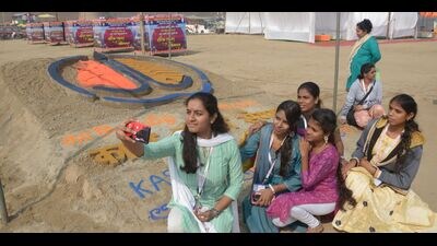 Guests being welcomed at Sangam and posing for photographs at the sand art created in their honour. (HT)