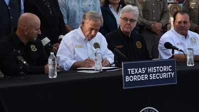 Gov. Greg Abbott signs three bills into law at a border wall construction site in Brownsville, Texas on Monday, Dec. 18, 2023, that will broaden his border security plans and add funding for more infrastructure to deter illegal immigration (AP Photo/Valerie Gonzalez) (AP) Gov. Greg Abbott signs three bills into law at a border wall construction site in Brownsville, Texas on Monday, Dec. 18, 2023, that will broaden his border security plans and add funding for more infrastructure to deter illegal immigration (AP Photo/Valerie Gonzalez) (AP)