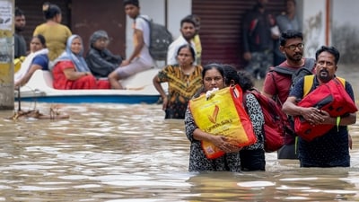 People shift from a flooded road after heavy rainfall, in Thoothukudi district, Tamil Nadu on Dec. 19 (PTI) People shift from a flooded road after heavy rainfall, in Thoothukudi district, Tamil Nadu on Dec. 19 (PTI)