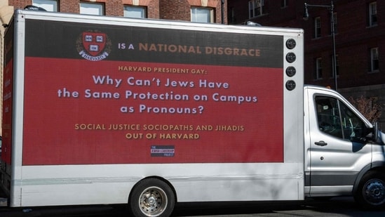A truck calling the president of Harvard a disgrace drives around Harvard University in Cambridge, Massachusetts on December 12, 2023 (Photo by Joseph Prezioso / AFP)