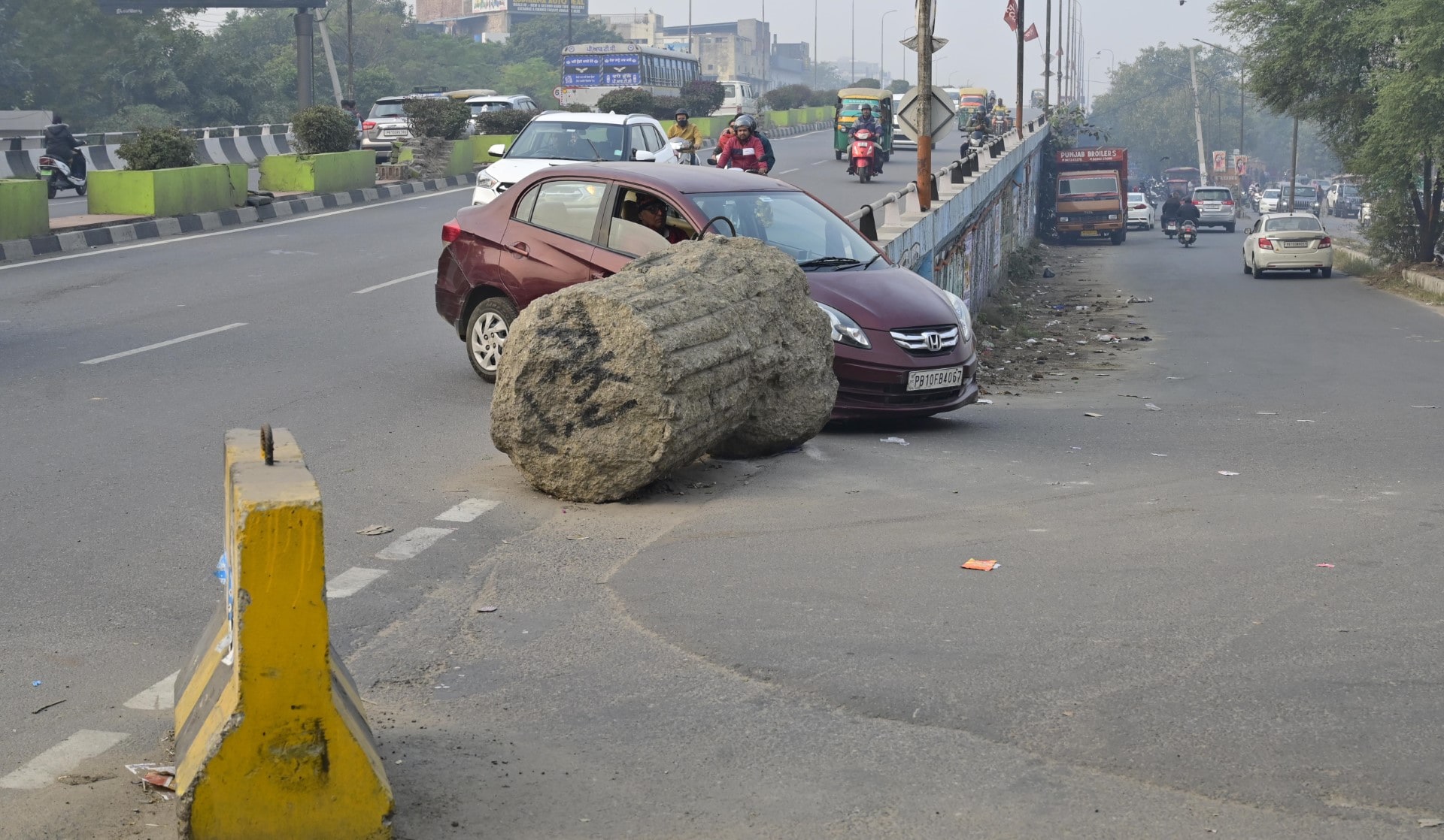 Commuters manoeuvreing past the boulders placed on the slip road at the ISBT flyover. (Gurpreet Singh/HT) Commuters manoeuvreing past the boulders placed on the slip road at the ISBT flyover. (Gurpreet Singh/HT)