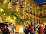 People stroll past Christmas lights and decorations at the outdoor Christmas market at Humboldt Forum in central Berlin, Germany. Holiday travel peaks in Europe despite security warnings ahead of Christmas 2023, New Year 2024 
