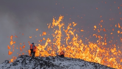 Scientists at the University of Iceland take measurements and samples standing on the ridge in front of the active part of the eruptive fissure of an active volcano in Grindavik on Iceland's Reykjanes Peninsula on December 19. (AP) Scientists at the University of Iceland take measurements and samples standing on the ridge in front of the active part of the eruptive fissure of an active volcano in Grindavik on Iceland's Reykjanes Peninsula on December 19. (AP)
