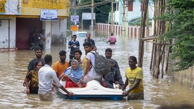 People shift from a flooded road after heavy rainfall, in Thoothukudi district, Tamil Nadu, Tuesday, Dec. 19, 2023. (PTI)